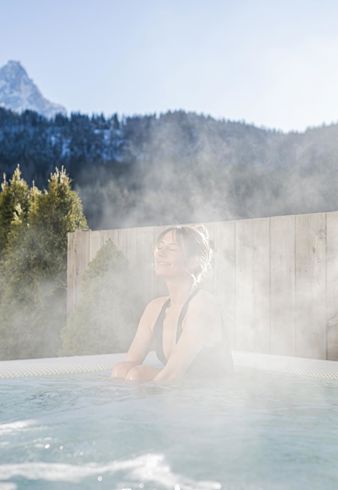 A woman is lying in the hot tub